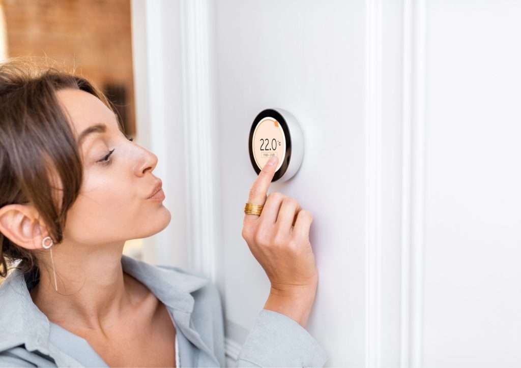 Heating Installation - Woman setting her digital thermostat