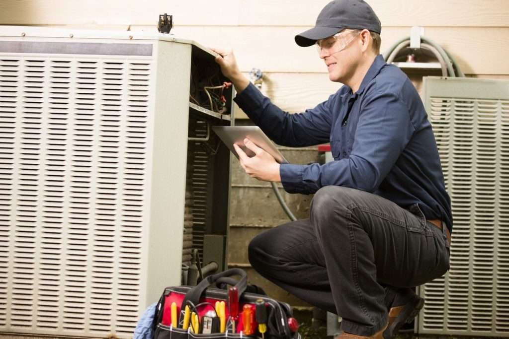 AC Inspection - HVAC Technician performing a thorough inspection on an HVAC unit