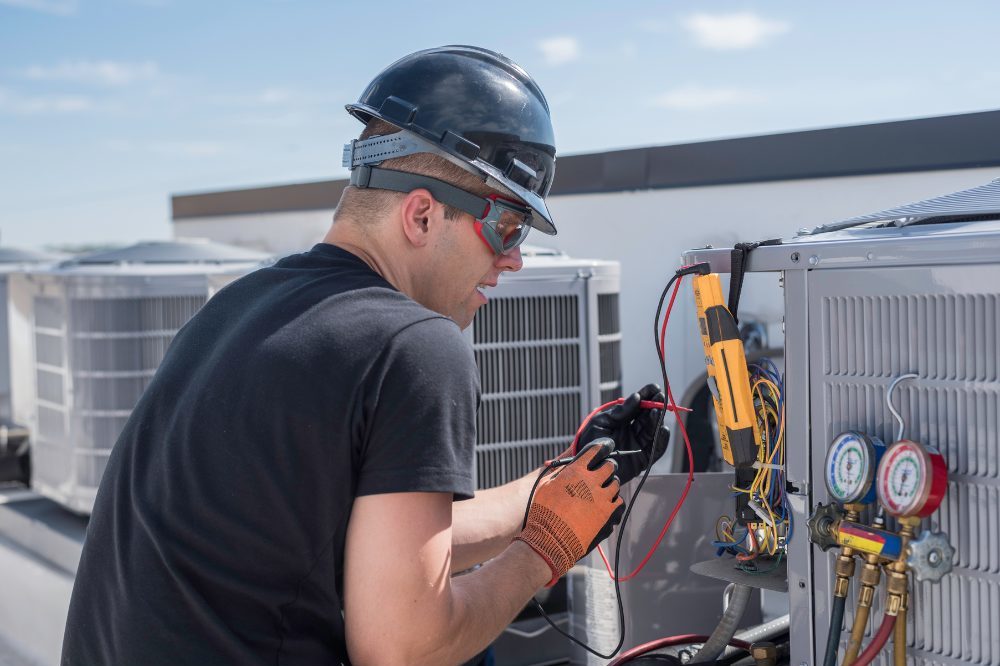 Commercial air conditioning installation - technician installing a commercial HVAC unit
