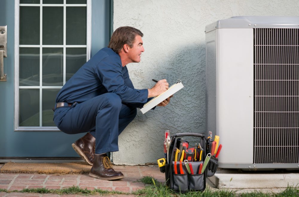Air Conditioner repair - technician inspecting HVAC unit