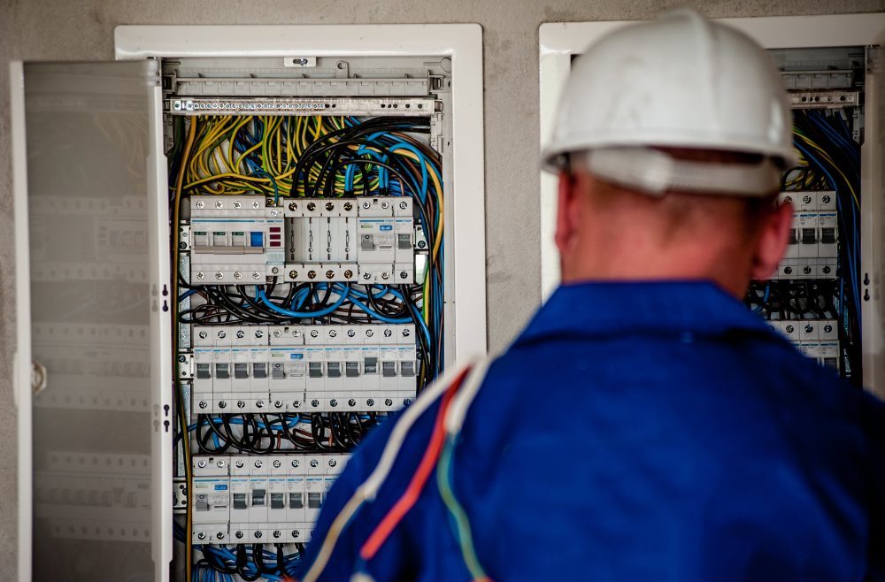 Professional electrician looking at a breaker panel